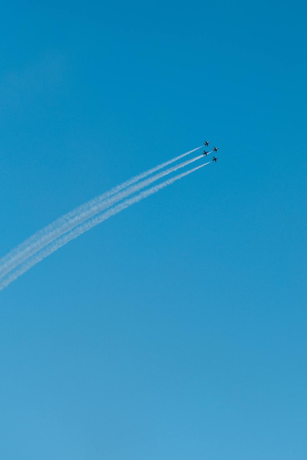 two airplanes flying in the sky leaving a trail of smoke behind them