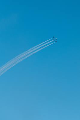 two airplanes flying in the sky leaving a trail of smoke behind them