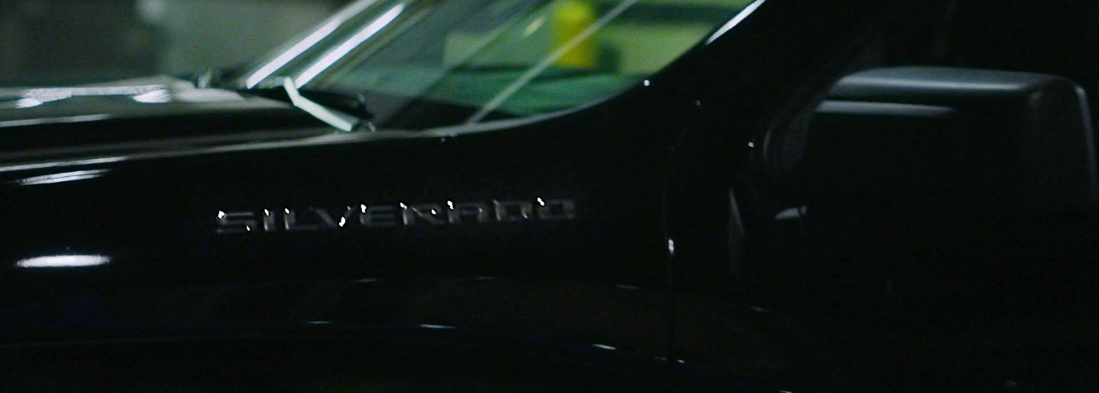 a close up of a black car with a yellow object in the background