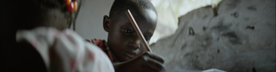 a young boy holding a pair of scissors in front of his face