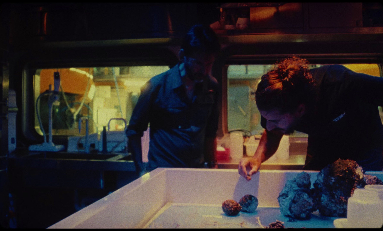 two men working in a kitchen preparing food