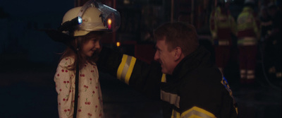 a fireman and a little girl standing next to each other