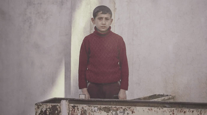 a man in a red sweater standing in a corner