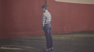 a man standing in front of a red wall