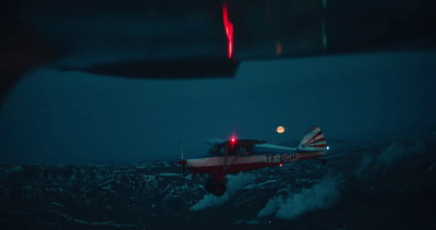 a small airplane flying over a mountain at night