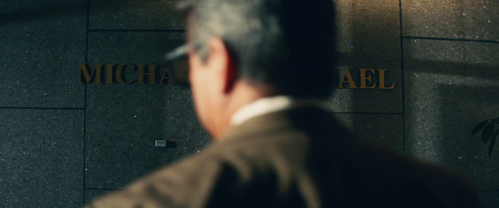 a man in a suit standing in front of a building