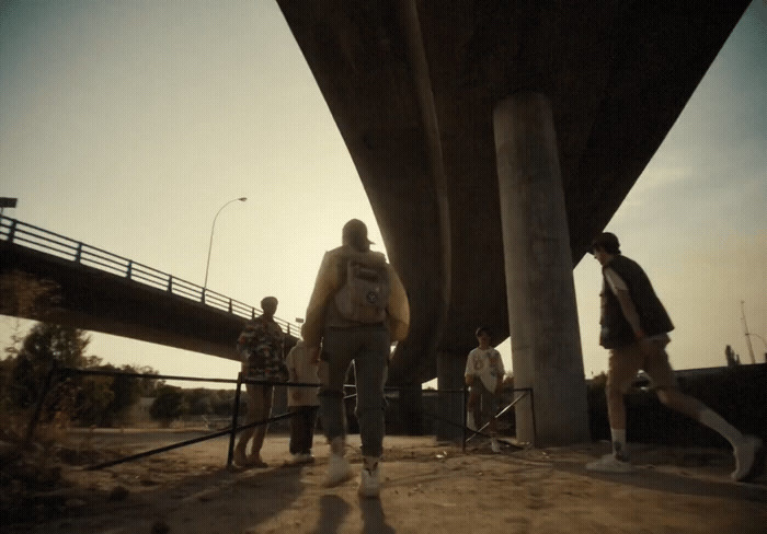 a group of people walking under a bridge