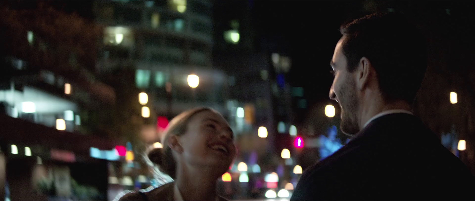 a man standing next to a woman on a city street