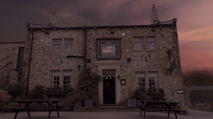 a stone building with two benches in front of it