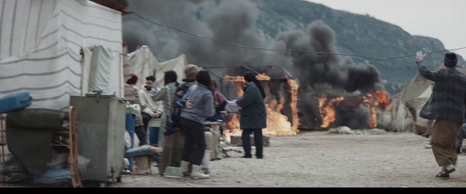 a group of people standing in front of a fire