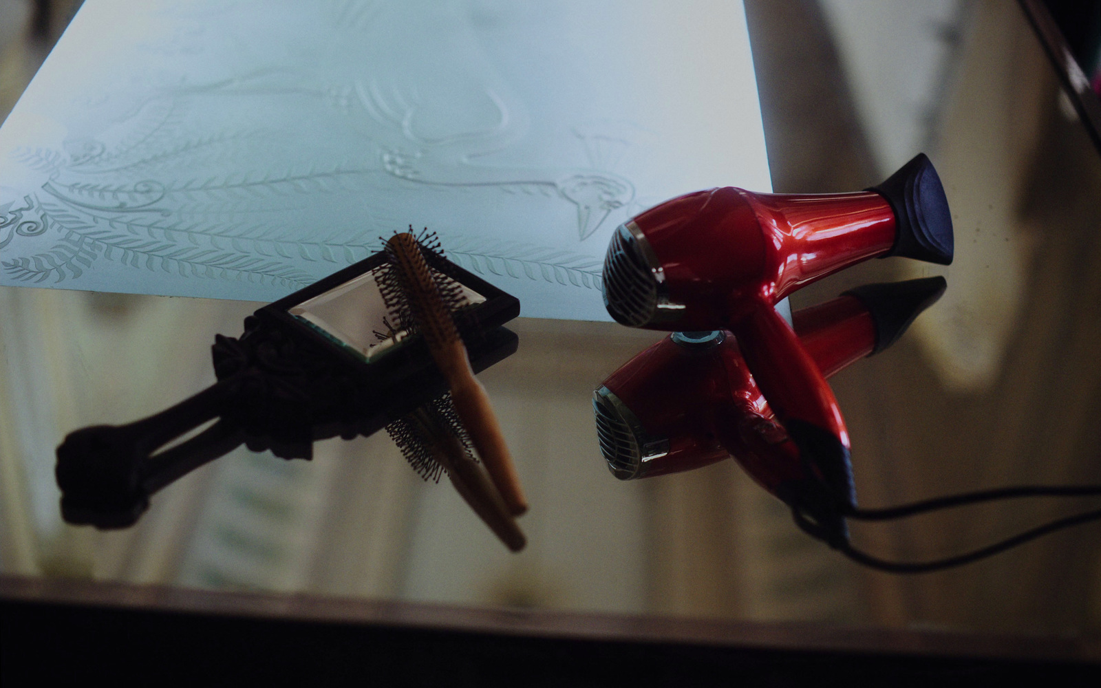 a close up of a hair dryer and a comb on a table