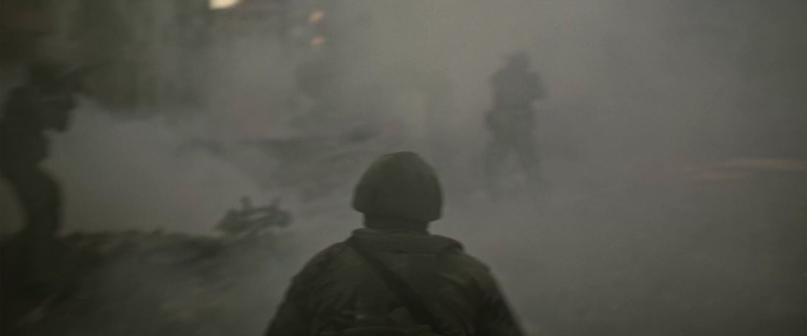 a person standing in a foggy area with a motorcycle