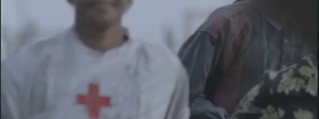 two men standing next to each other with a red cross on their shirt