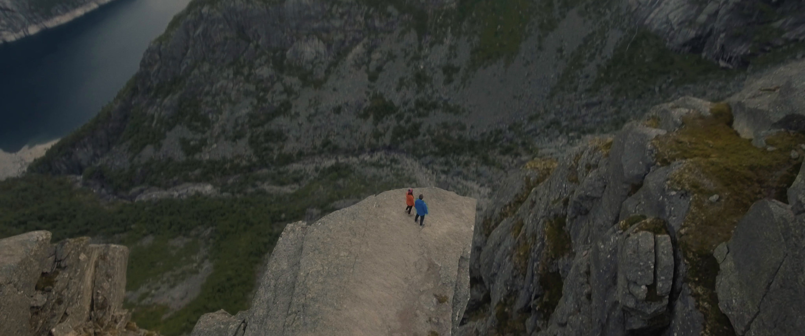 a man is walking down a rocky mountainside