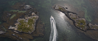 an aerial view of a boat traveling through a body of water