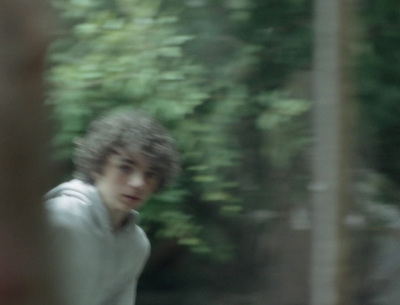 a blurry photo of a young man in a white shirt