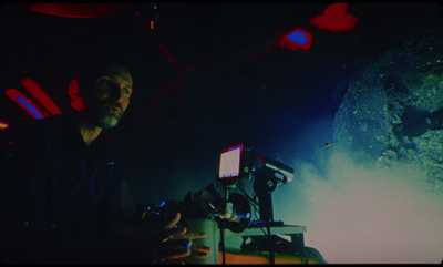 a man standing next to a machine in a dark room