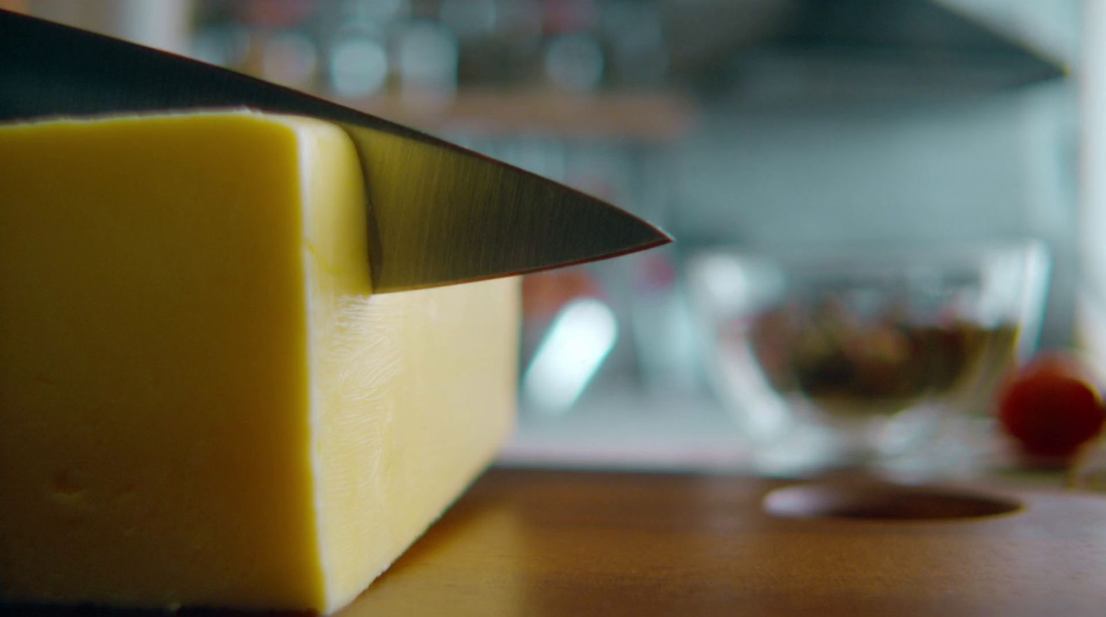 a block of cheese with a knife sticking out of it