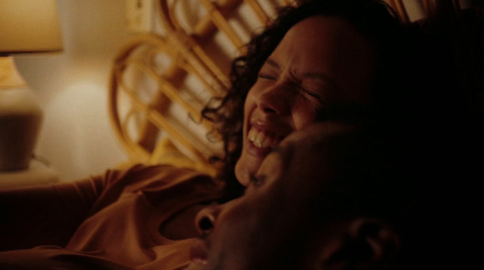 a man and a woman laying in bed laughing