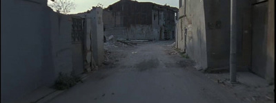 an alley way with a stop sign and a building in the background