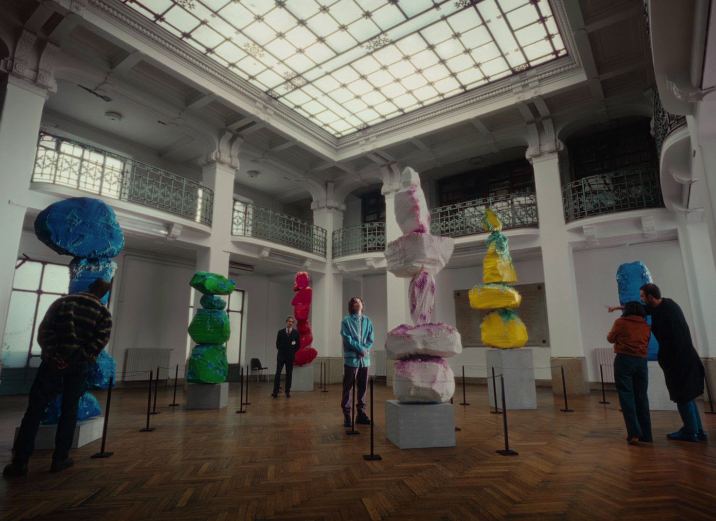 a group of people standing in a room with sculptures