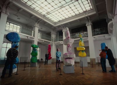 a group of people standing in a room with sculptures