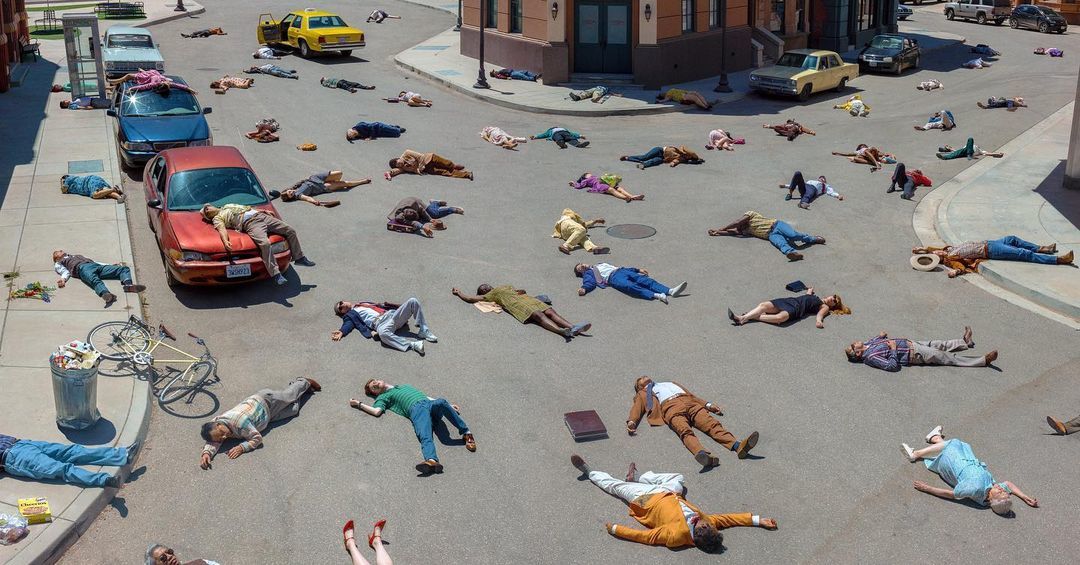 a group of people laying on the ground in the middle of a street