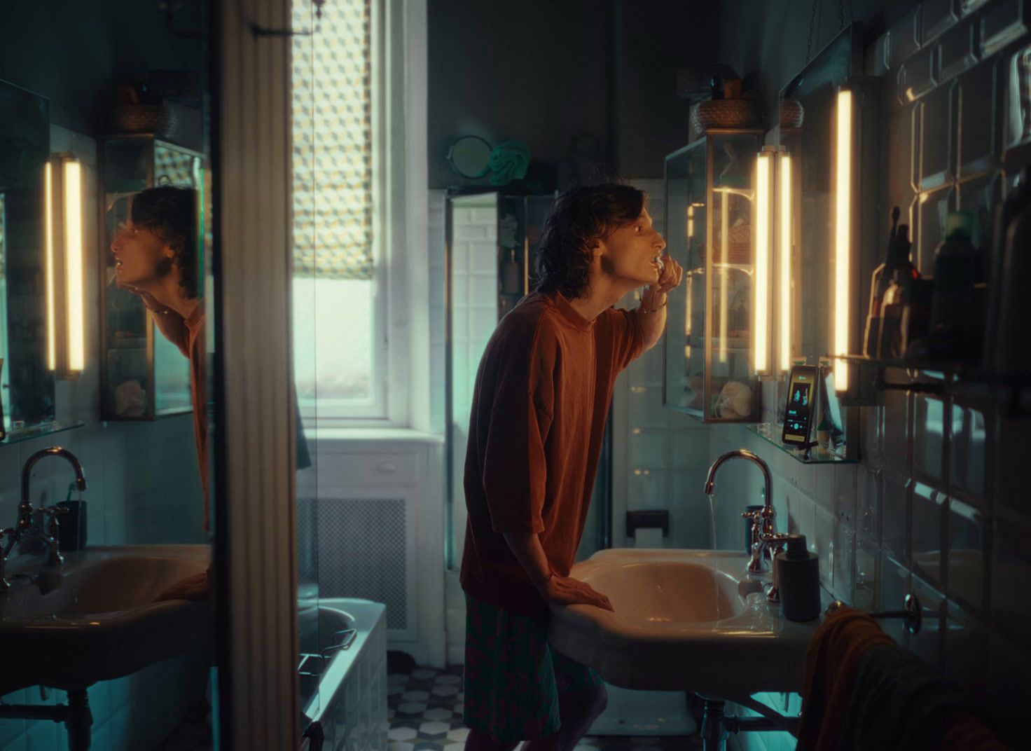 a man standing in front of a bathroom sink