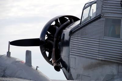 an old airplane with a propeller sitting on top of a tarmac