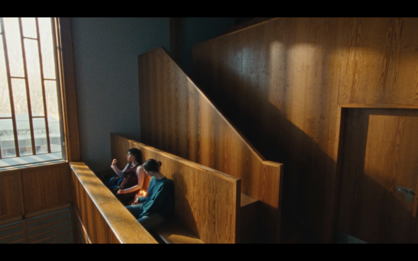 a couple of people sitting on top of a wooden bench