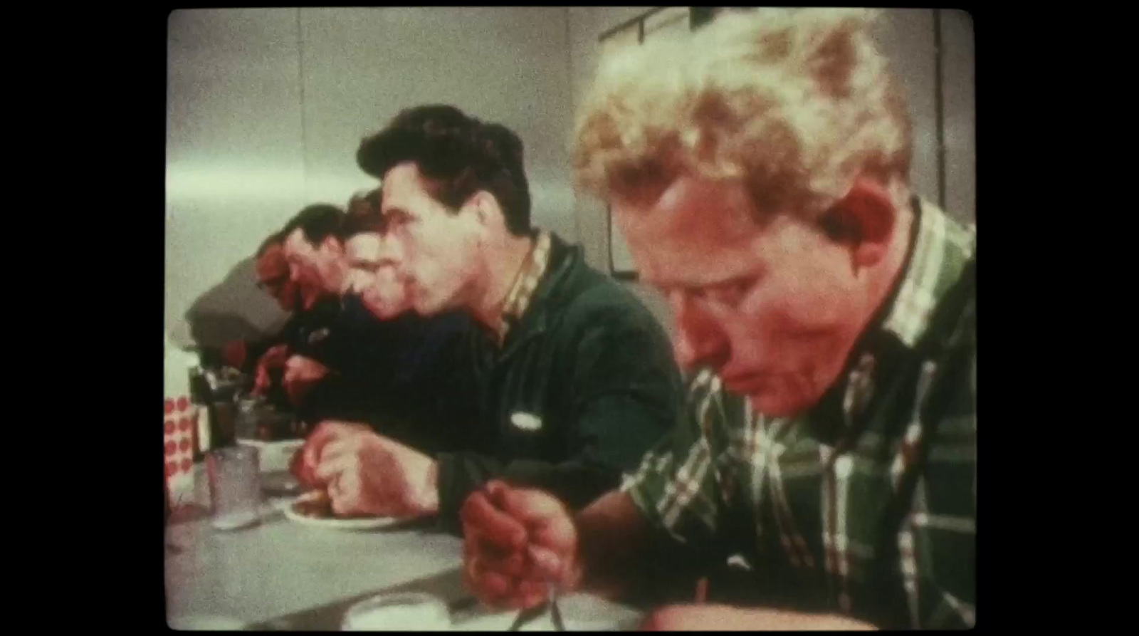 a group of men sitting at a table eating food