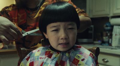 a little girl getting her hair cut by an adult