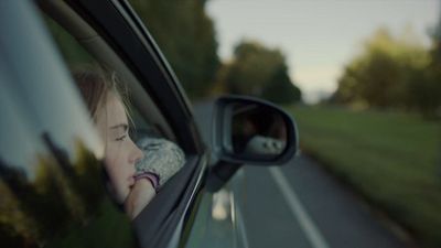 a woman is looking out the window of a car