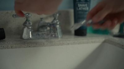 a person fixing a faucet in a bathroom sink