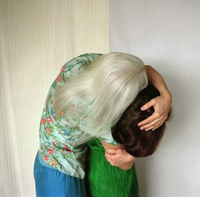 a woman in a green dress leaning against a wall