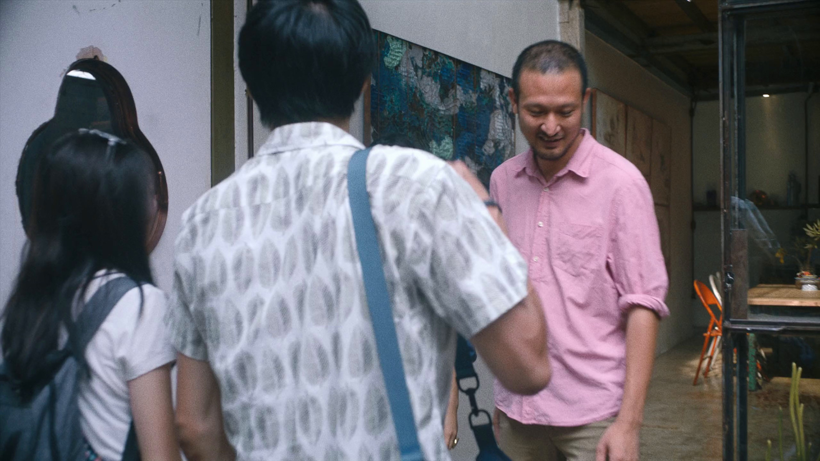 a man standing next to a woman in a pink shirt