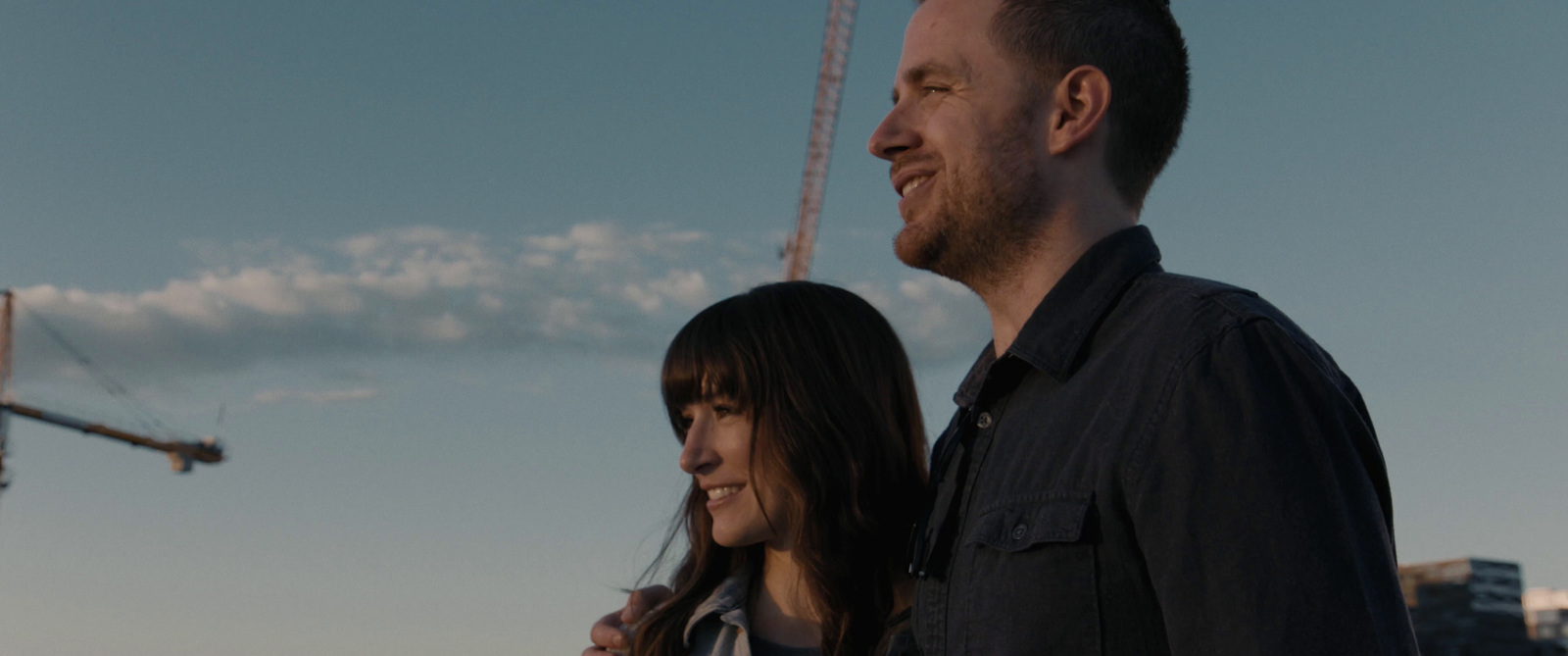 a man and woman standing in front of a construction site