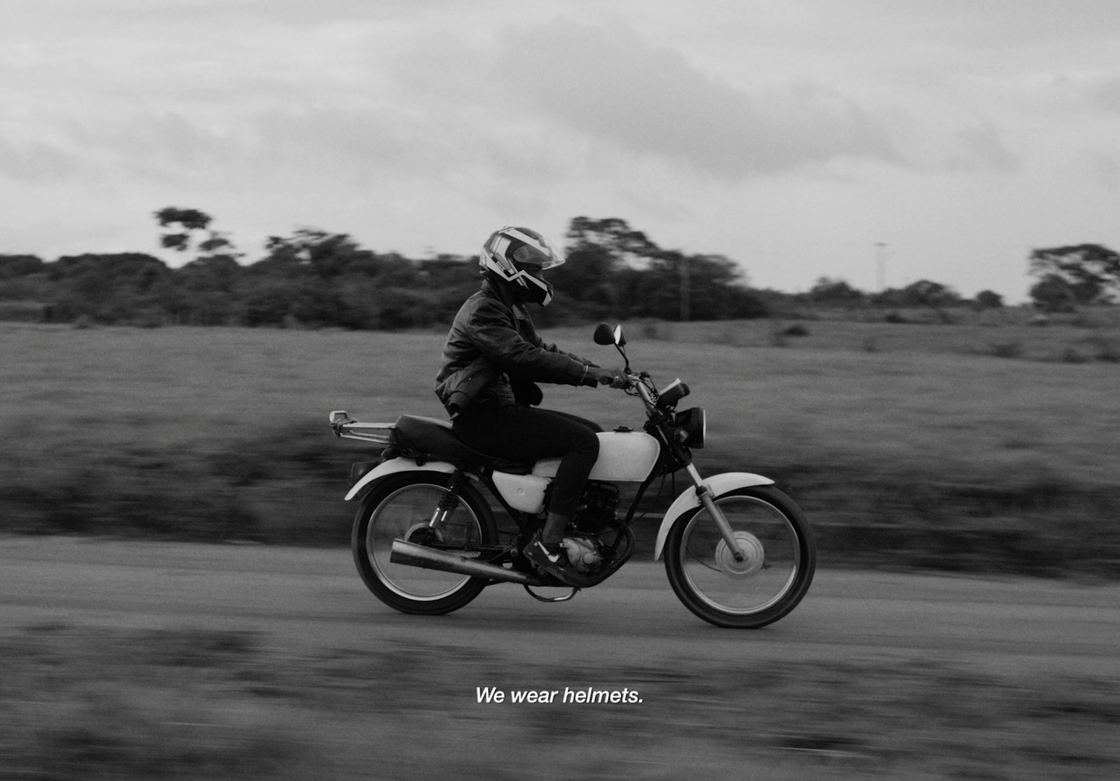 a black and white photo of a person riding a motorcycle