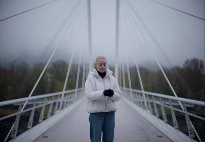 a woman standing on a bridge in the rain