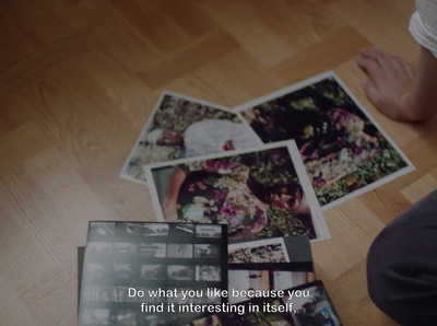 a person sitting on the floor with a bunch of pictures on the floor