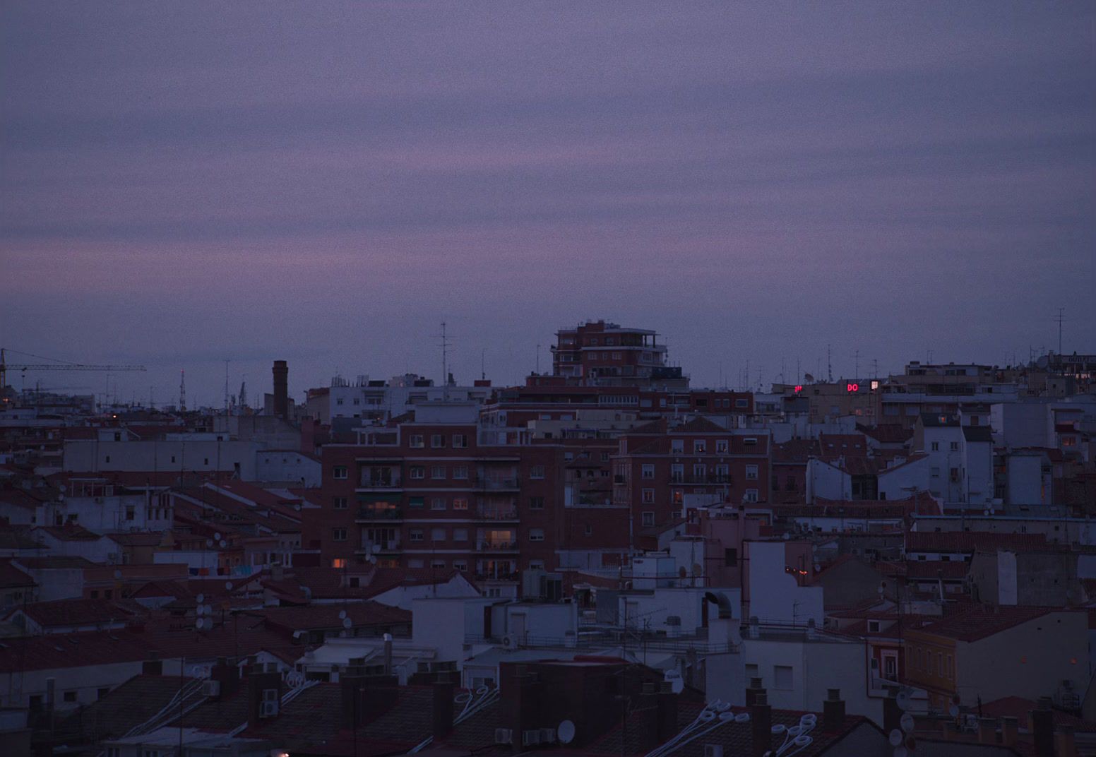 a view of a city at dusk from a rooftop