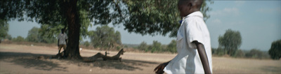 a man in a white shirt is walking in a field