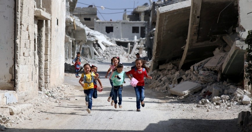 a group of children running down a street