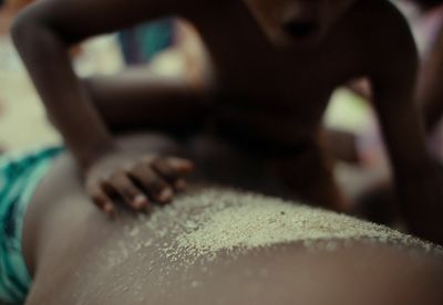 a person laying on top of a person covered in sand