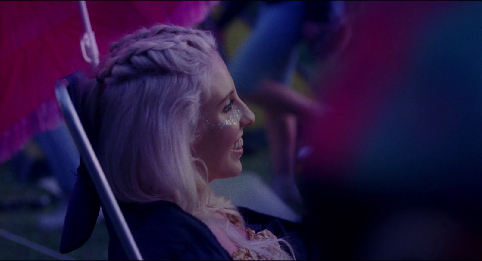 a woman with blonde hair holding a pink umbrella