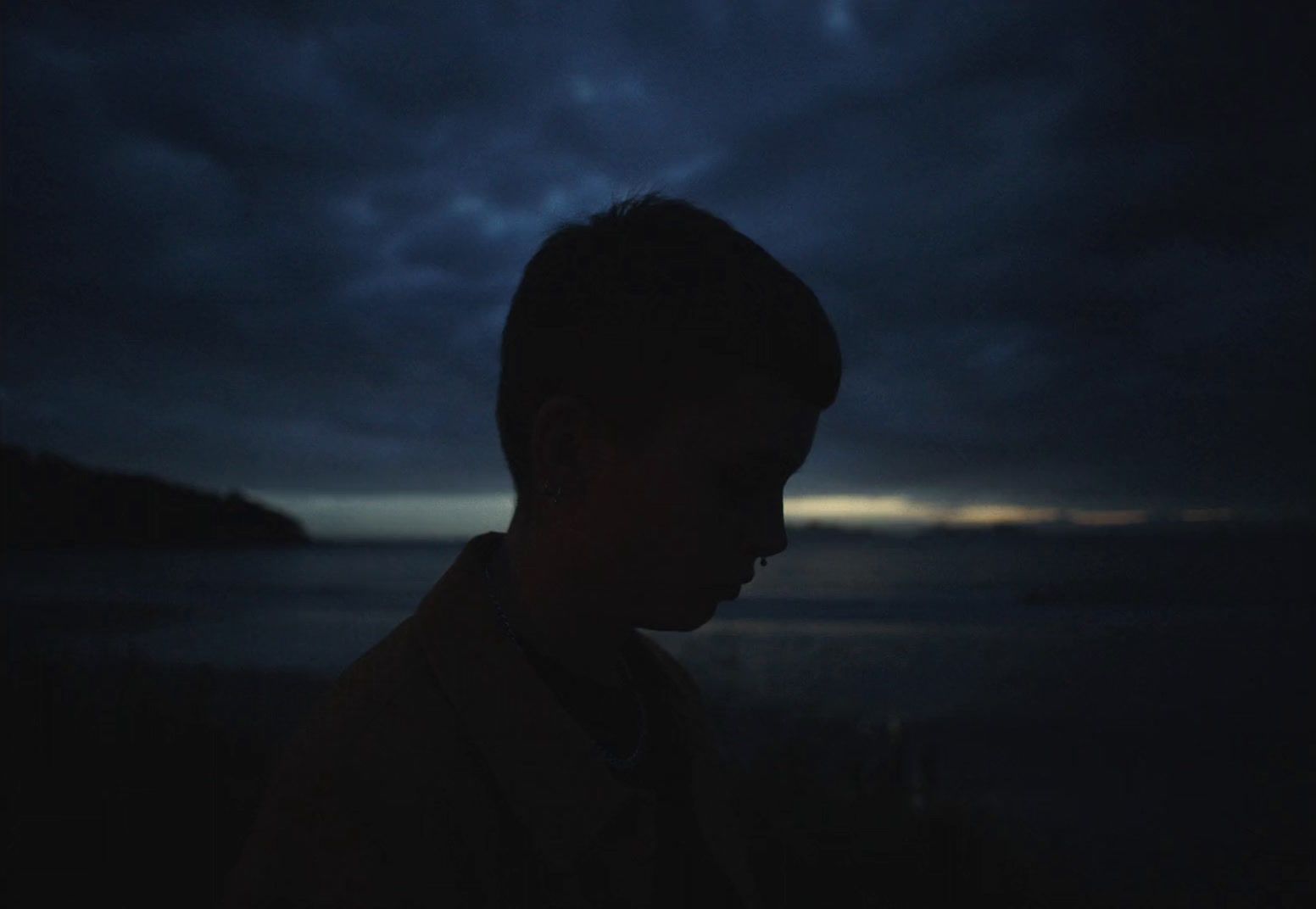 a man standing in the dark with a dark sky in the background