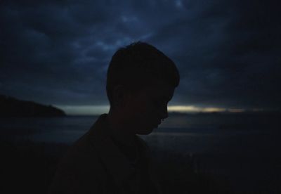 a man standing in the dark with a dark sky in the background