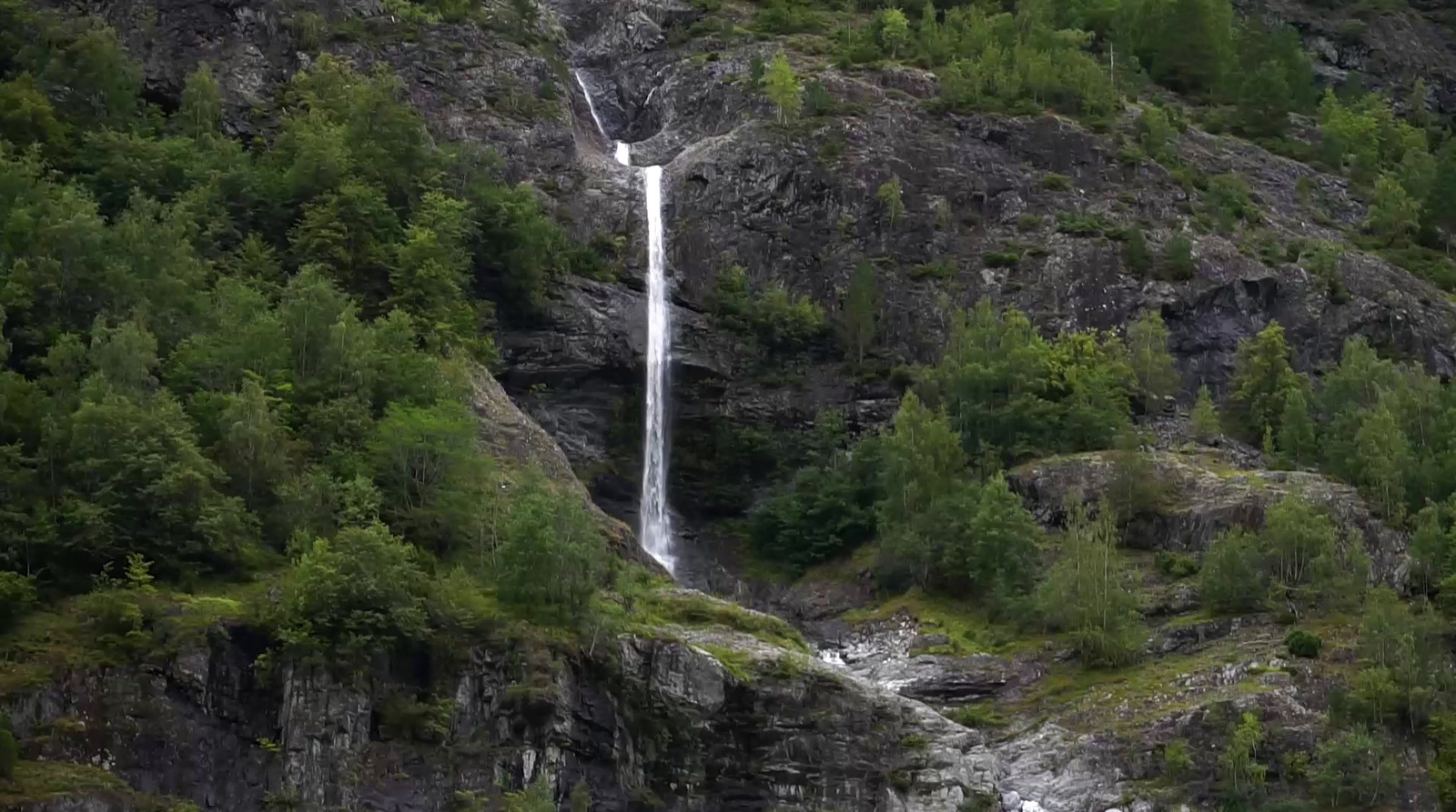 a waterfall is flowing down the side of a mountain