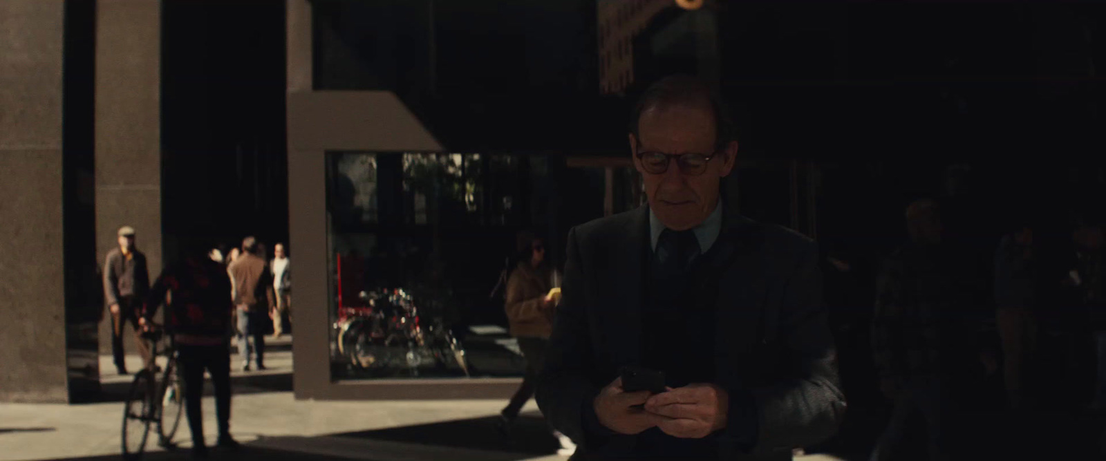 a man in a suit and tie looking at his cell phone