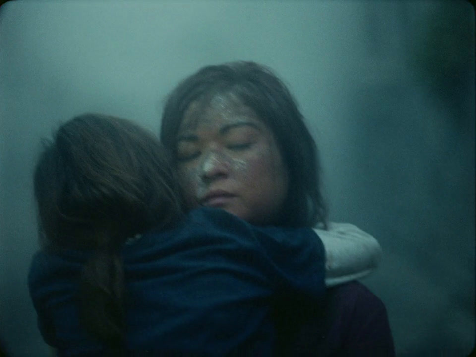 a woman hugging another woman in a dark room